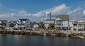 A waterfront residential area with houses, a water tower, and a dock. - Sea Pond Villa Unit 3 (North Myrtle Beach)