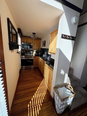 A kitchen with wooden cabinets, stainless steel appliances, and a window allowing natural light.