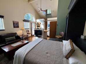 A bedroom with a bed, a TV, a desk, and a chair.