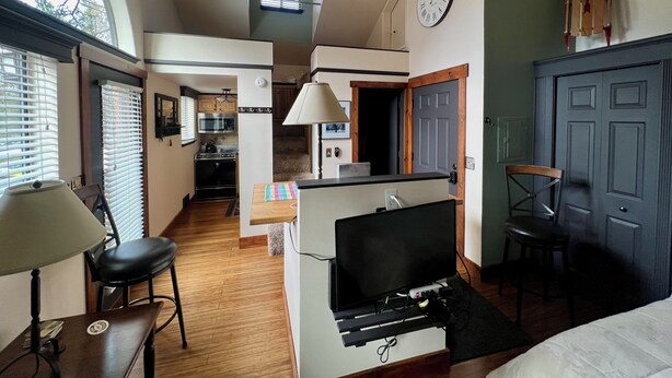 Un espacio habitable pequeño con kitchenette, comedor y televisor.