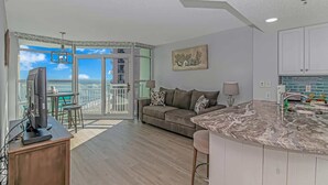 En moderne lejlighed med balkon, opholdsstue og køkken.