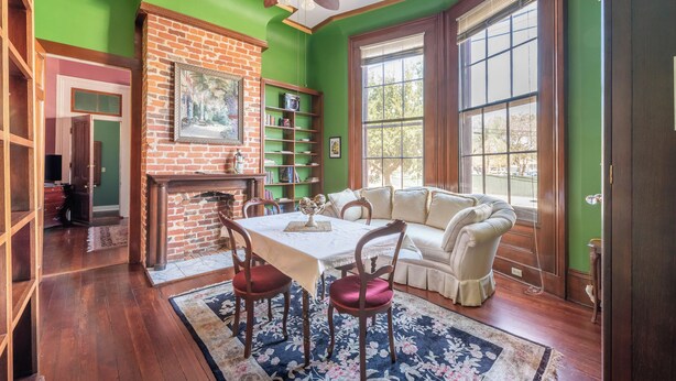 A dining area with a brick fireplace, wooden table, and chairs. - New Orleans Suite-Lower Garden District (New Orleans)