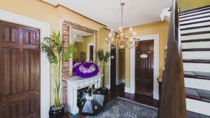 A foyer with a fireplace, a chandelier, and a staircase. - New Orleans Suite-Lower Garden District (New Orleans)