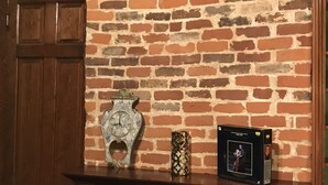 A brick fireplace with a mantel shelf displaying a clock, a decorative vase, and a framed picture. - New Orleans Suite-Lower Garden District (New Orleans)