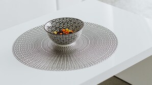Una mesa de centro blanca con un cuenco decorativo.