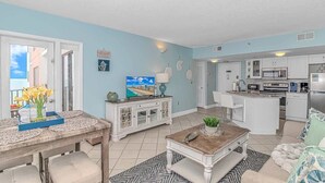 Una cocina moderna con armarios blancos, un microondas y un refrigerador.