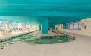 Une piscine intérieure dont la profondeur maximale est de 3 pieds, avec un panneau indiquant la présence d’un sauveteur et un autre panneau interdisant de plonger.