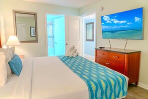 A hotel room with a bed, a dresser, a television, and a view of the ocean. - Sandy Beach 1612 (Myrtle Beach)
