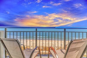 Un balcone con ringhiere in metallo che si affaccia su una spiaggia.