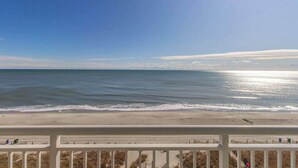 A beach view from a balcony with a railing, ocean, and clear sky. - Carolinian 731 (Myrtle Beach)