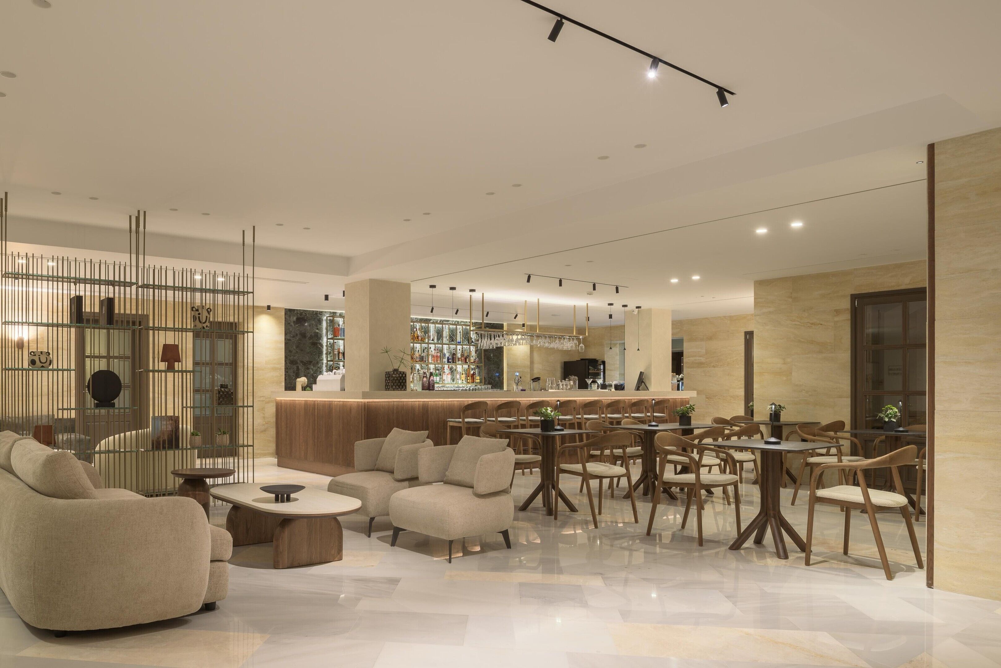 A modern interior with a bar area, seating arrangements, and a decorative partition.