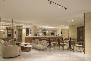 A modern interior with a bar area, seating arrangements, and a decorative partition.