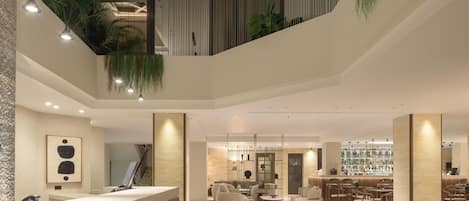 A modern lobby with a reception desk, seating area, and a bar.