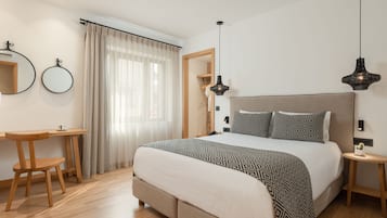 A bedroom with a bed, bedside tables, a desk, and a chair.