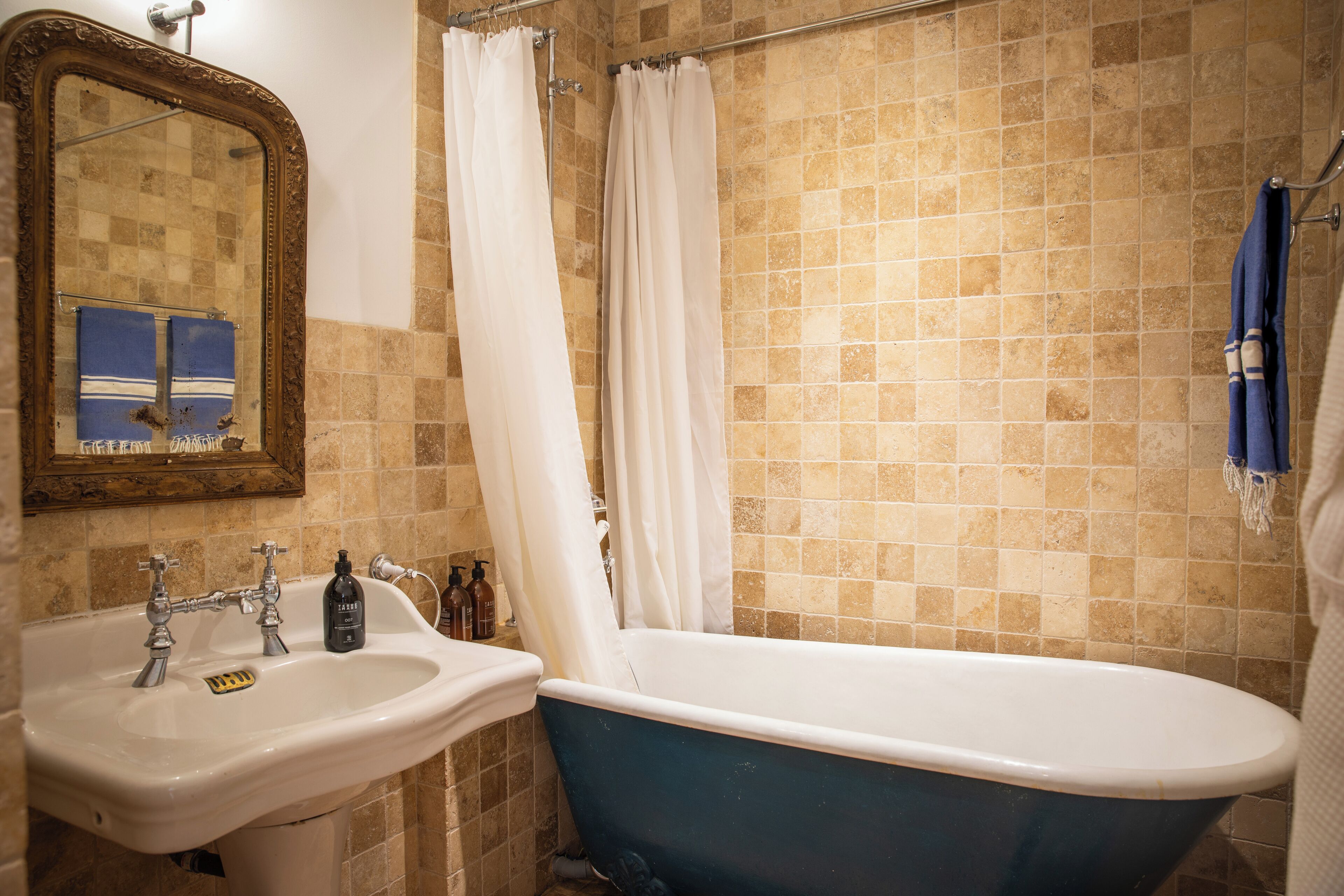 A bathroom with a bathtub, a sink, and a mirror.