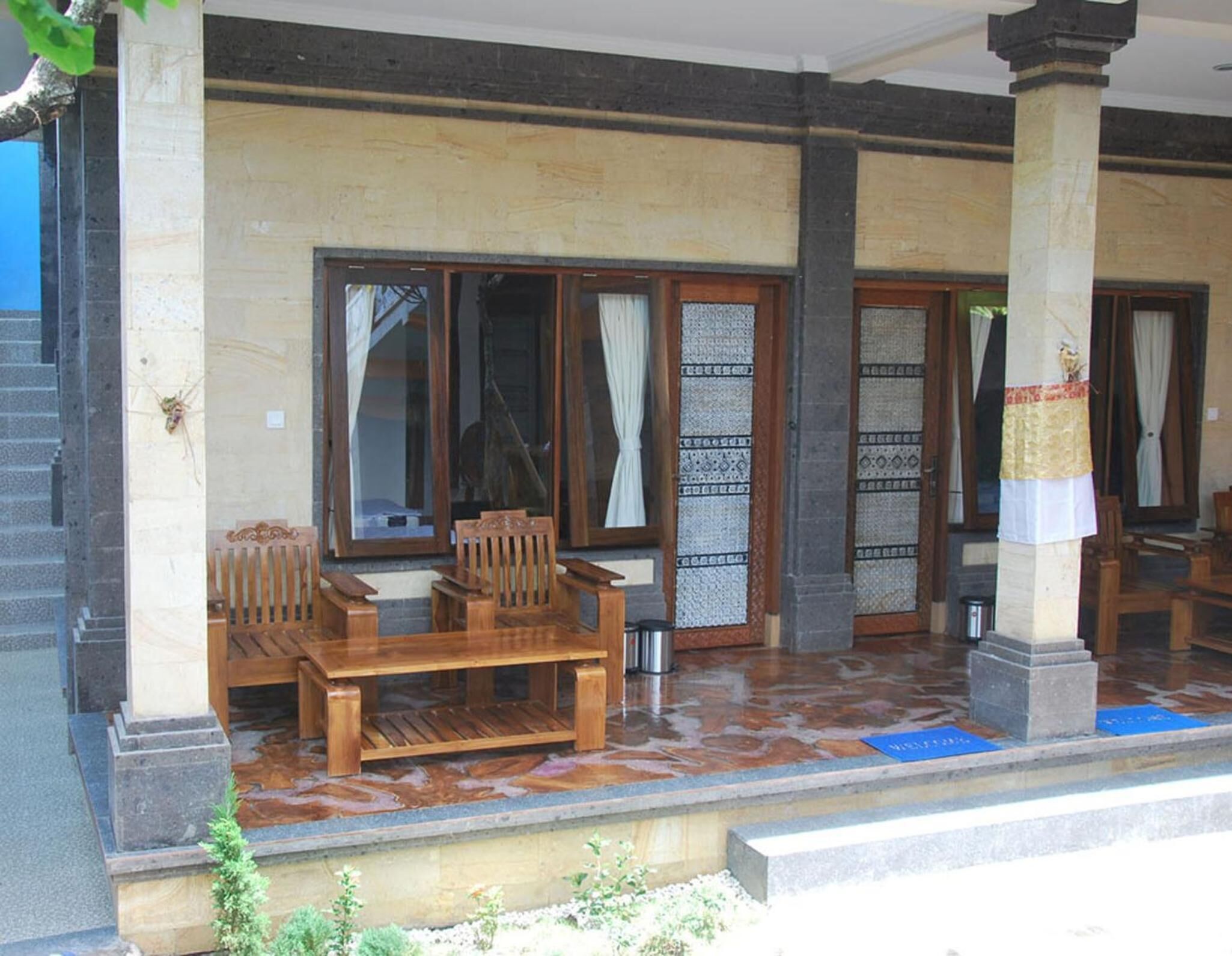 A covered outdoor seating area with wooden benches and a tiled floor.