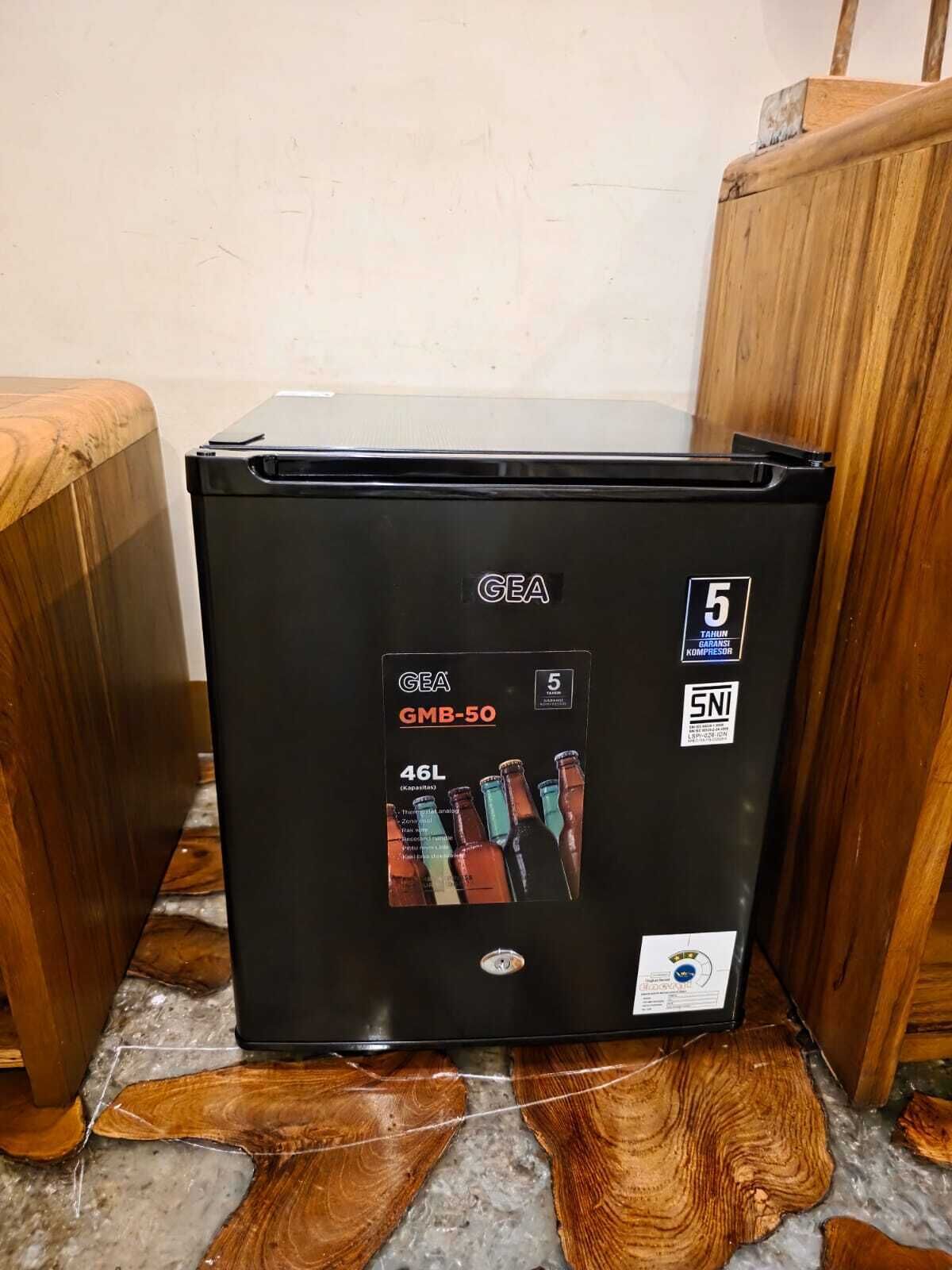 Een GEA GMB-50 koelkast met een inhoud van 46 liter, geplaatst op een vloer met houten planken.