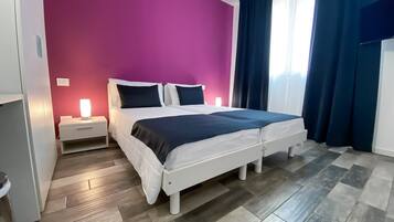 Une chambre avec un lit, des tables de chevet et une fenêtre avec des rideaux.