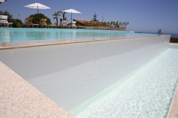 Piscina externa sazonal, funciona das 8h às 20h, guarda-sóis