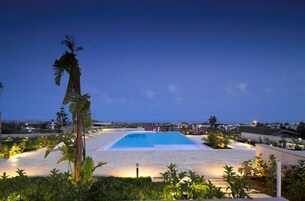 Una piscina al aire libre de temporada, sombrillas