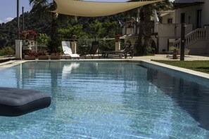 A clear swimming pool with lounge chairs and a canopy. - Tenuta Santa Tecla (Acireale)