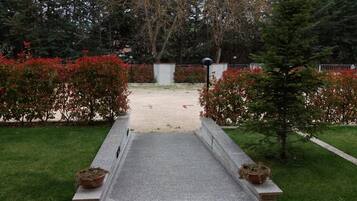 Un sendero lleva a un edificio rodeado de vegetación y una zona de grava.