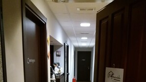 A hotel corridor with doors on both sides, a reception desk, and a fire extinguisher. - Affittacamere il Boscaiolo (L'Aquila)