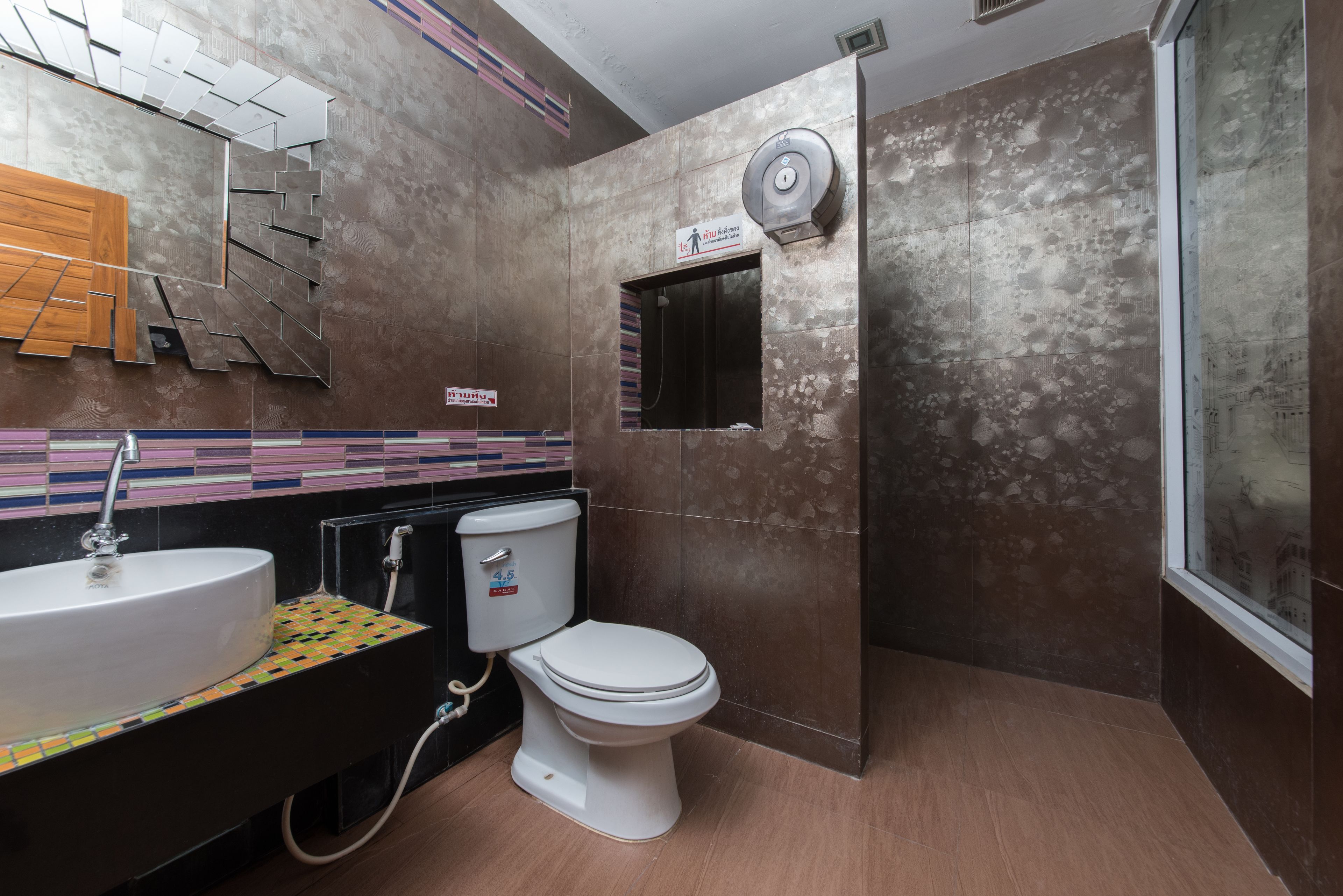 Un baño moderno con lavamanos, inodoro y ducha.