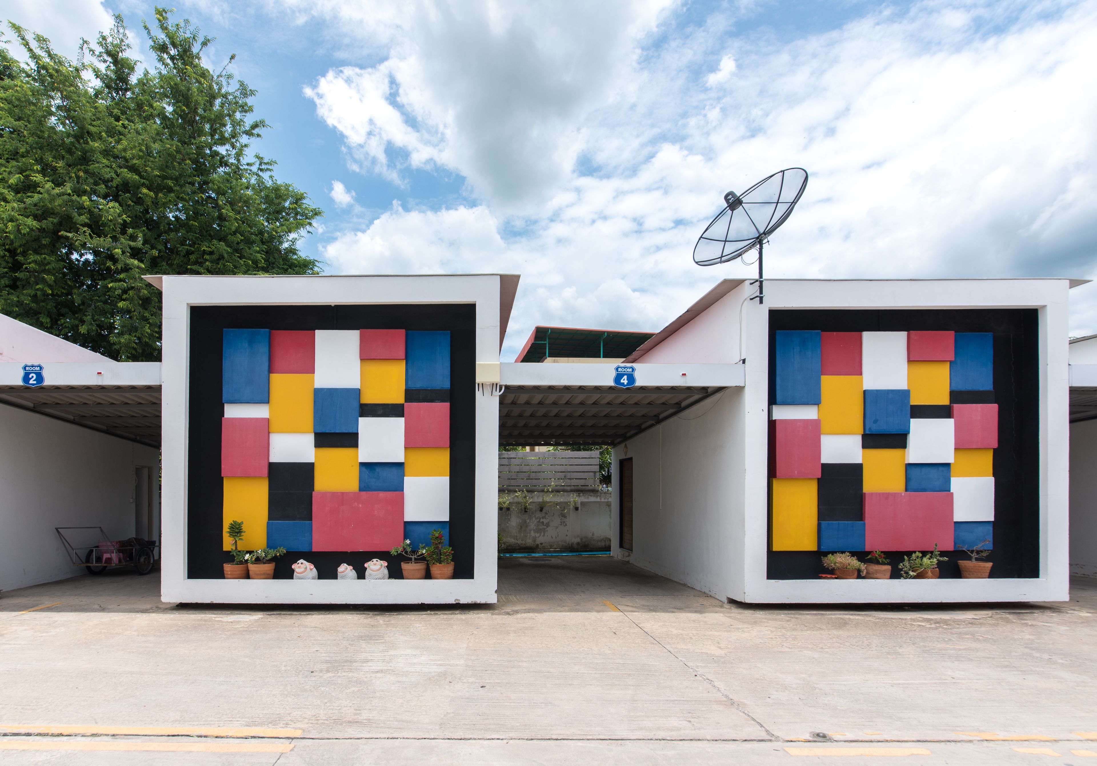 A modern building with colorful geometric wall art and satellite dishes.