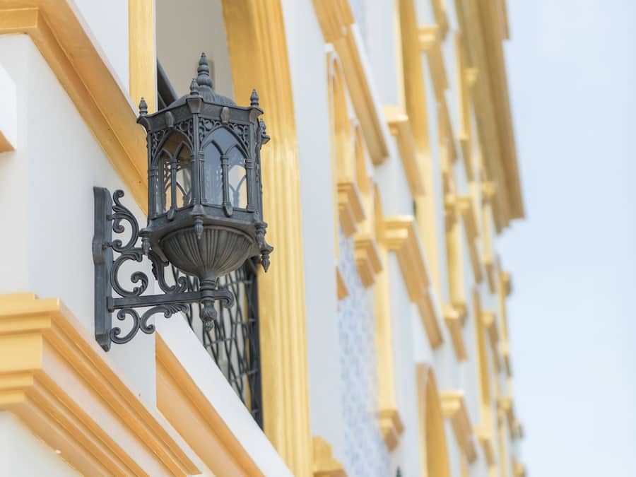A building facade with ornate black lanterns and yellow trim.