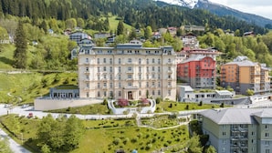 Un hotel de varios pisos con un patio central, rodeado de exuberante vegetación y un paisaje montañoso.