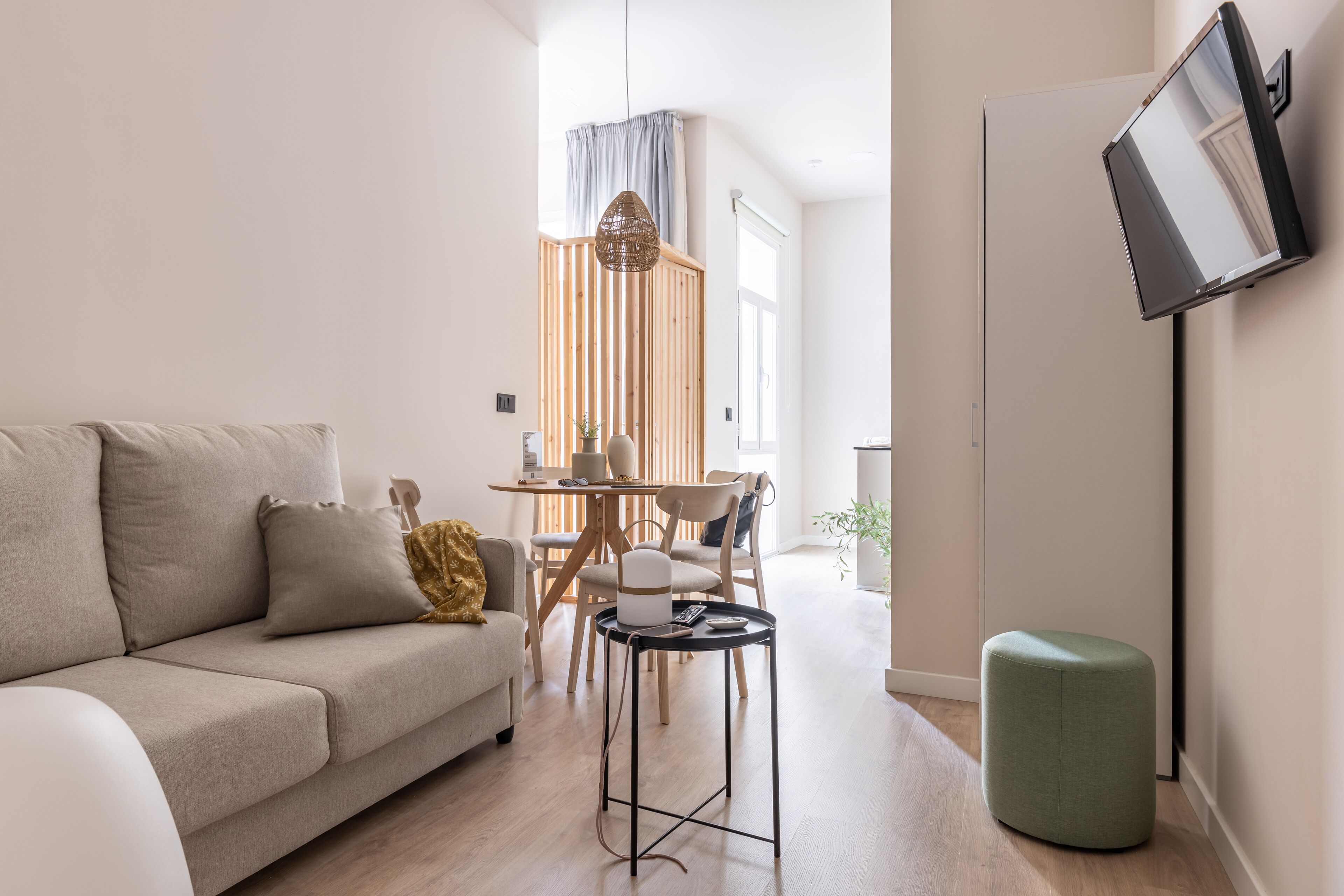 Una sala moderna con un sofá, una mesita y un pouf verde.