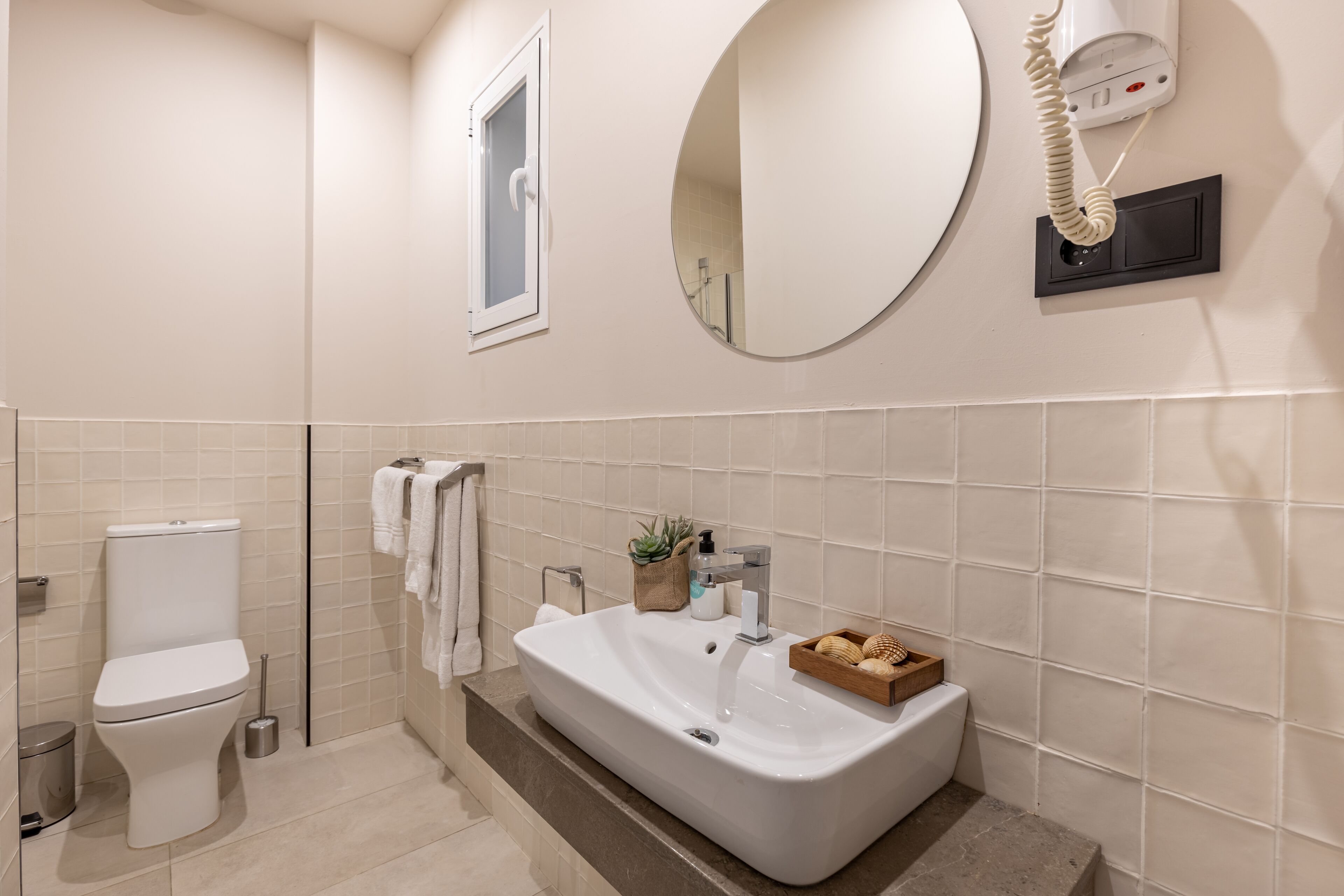 A modern bathroom with a toilet, sink, and mirror.
