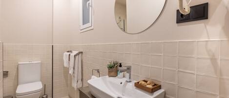 A modern bathroom with a toilet, sink, and mirror.