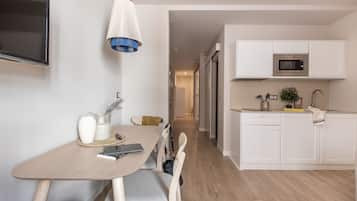 A modern kitchen with white cabinets, a microwave, and a sink.