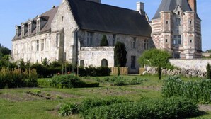 A historic stone building with a large garden in front. - Manoir du Plessis au Bois (Vauciennes)