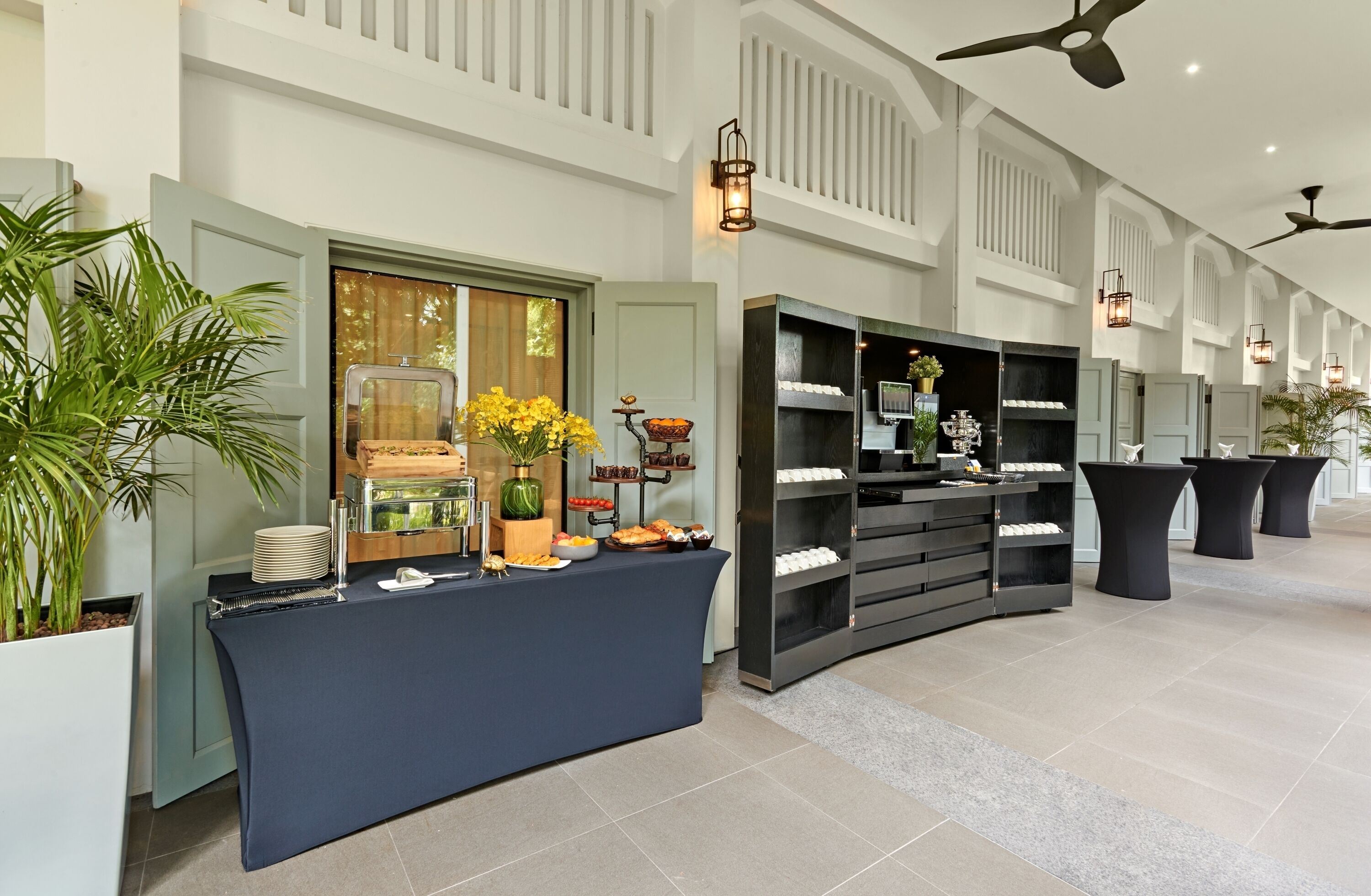 A buffet setup with a variety of food items, a coffee station, and decorative plants.