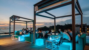 Un área de estar al aire libre con muebles modernos y vista al agua.