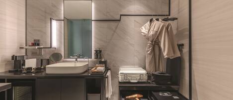 A modern bathroom with a large mirror, a sink, a vanity, and a robe hanging on a rack.