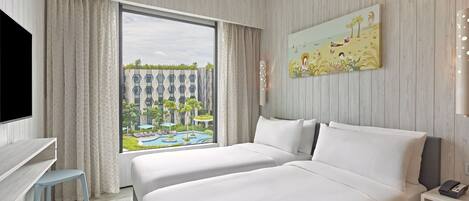 A hotel room with a large window, two beds, a desk, and a painting.