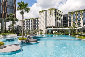 Ein modernes Hotel mit Poolbereich, der schichtförmige Schwimmbecken und Liegestühle bietet.