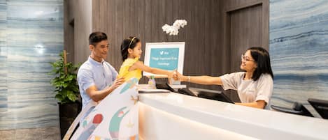 Una mesa de recepción con un cartel enmarcado que dice 'Village Important Kids Concierge'.