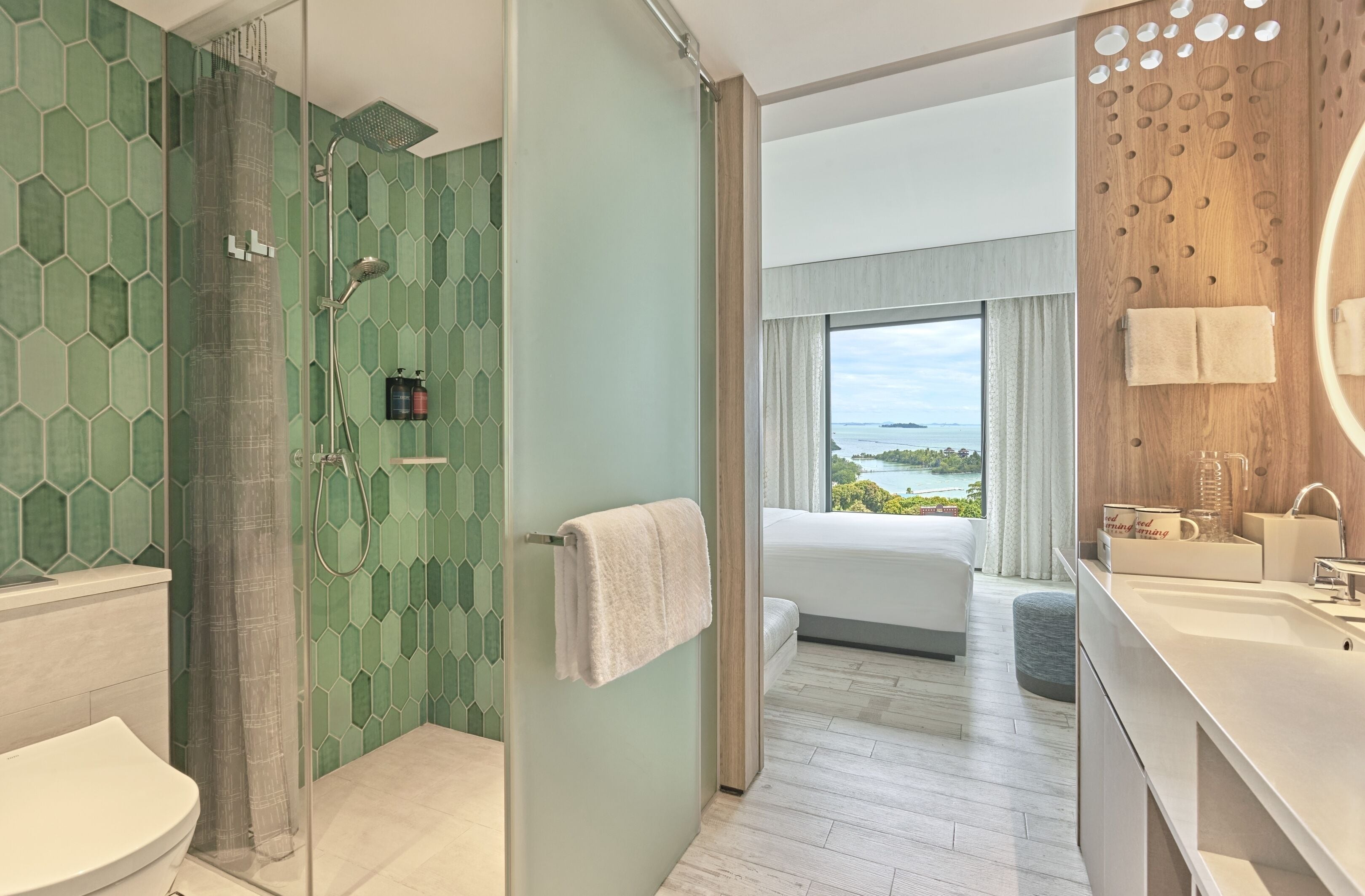 A modern bathroom with a shower, toilet, and sink.