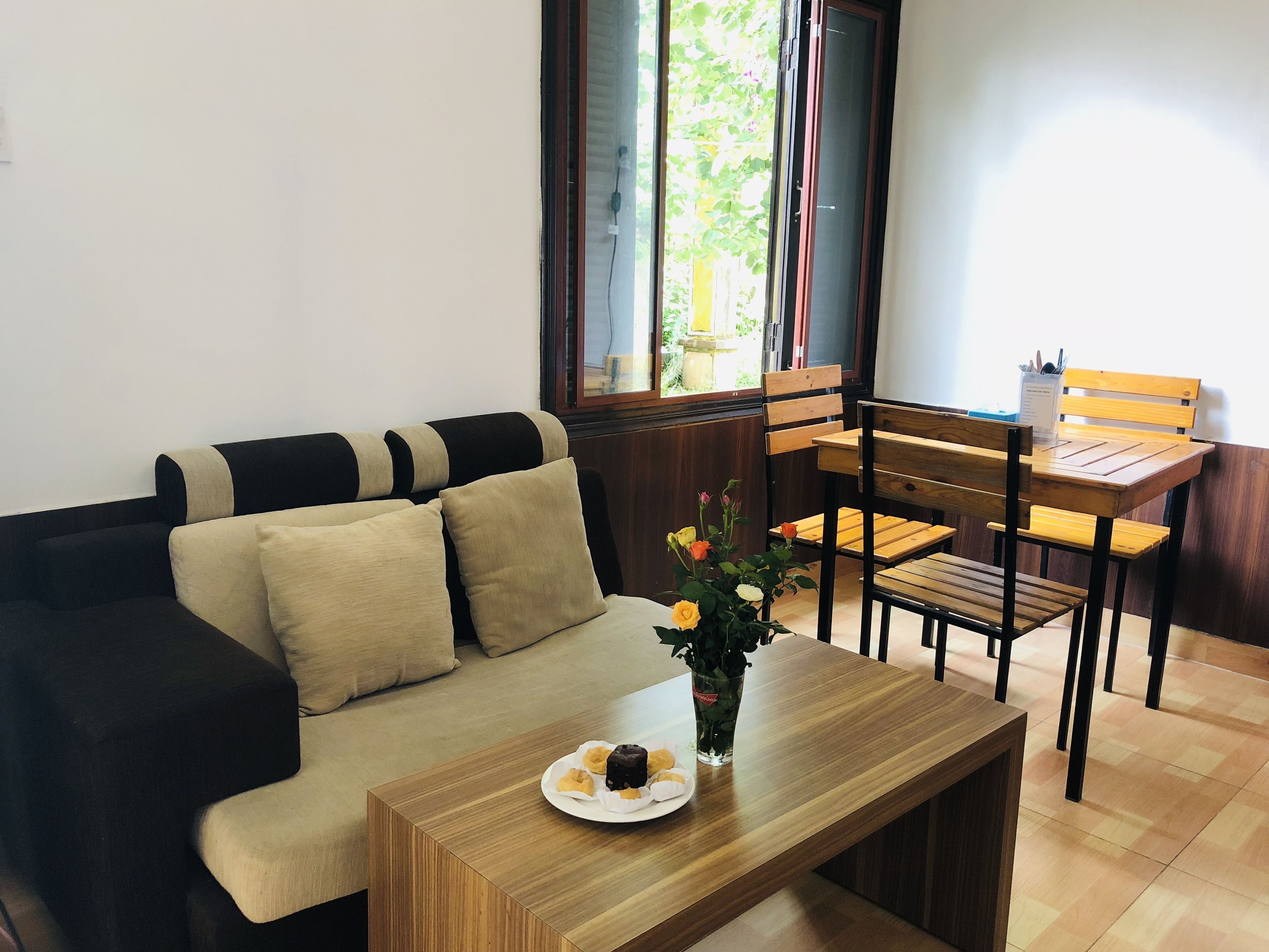 Un espacio de estar con un sofá, una mesa de madera y un comedor.