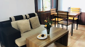 Una sala moderna con un sofá, una mesa de centro de madera y un comedor con una mesa y sillas de madera.