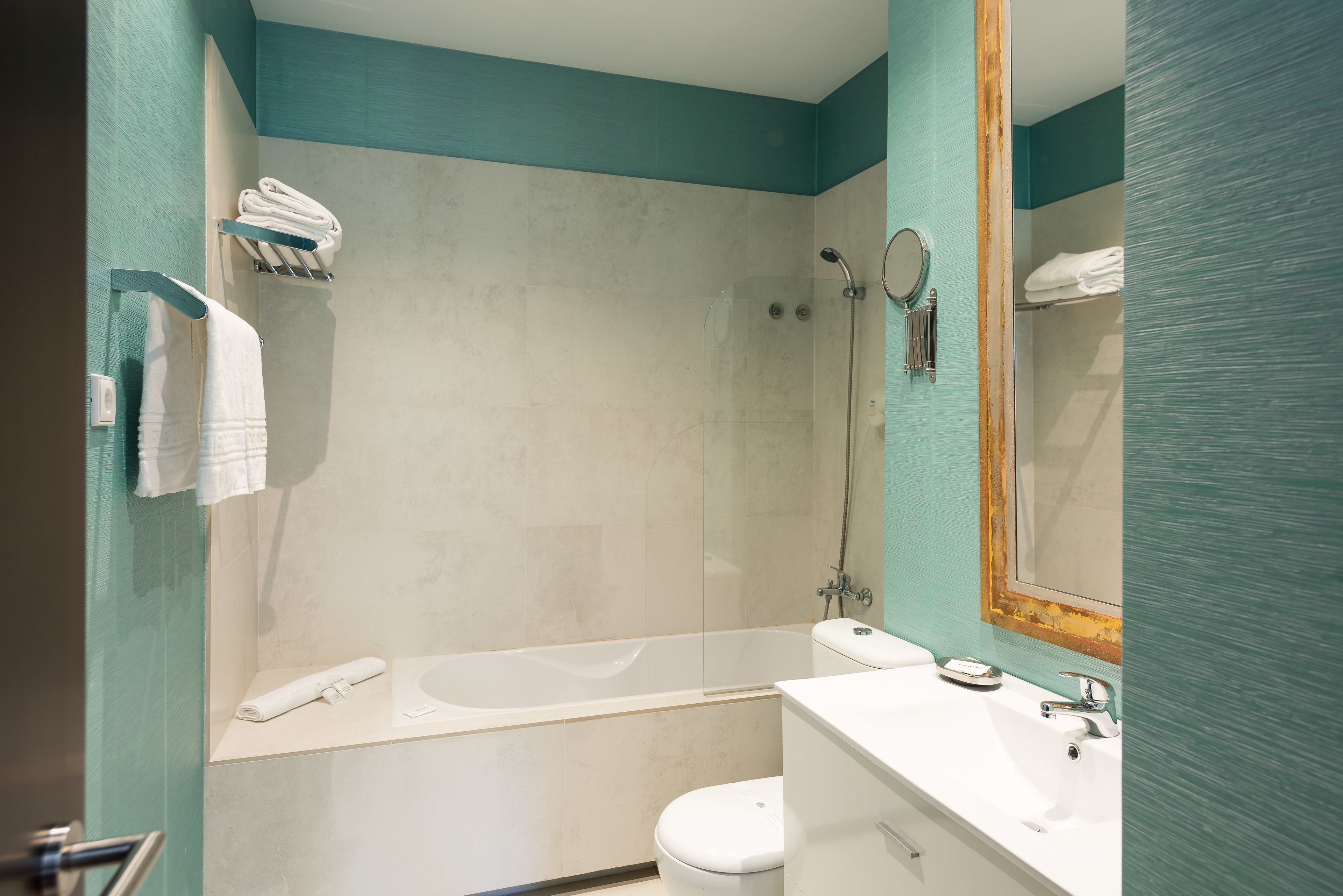 A modern bathroom with a bathtub, toilet, and sink.