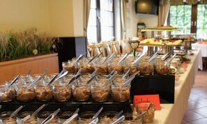 Un bufé con diversos alimentos y utensilios.