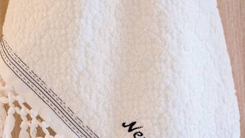 Una toalla blanca con flecos y texto bordado.