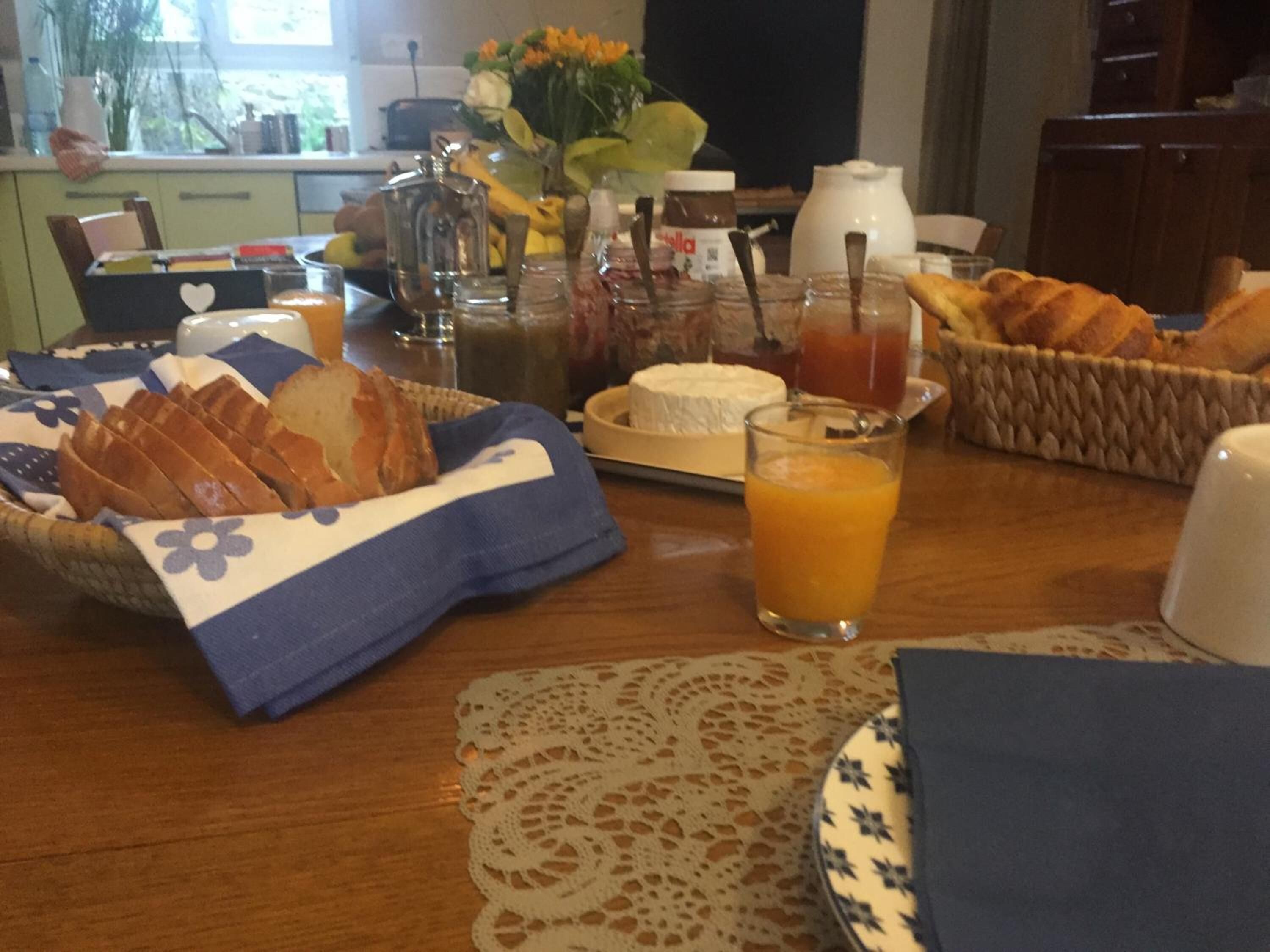 A breakfast table with bread, cheese, and juice.