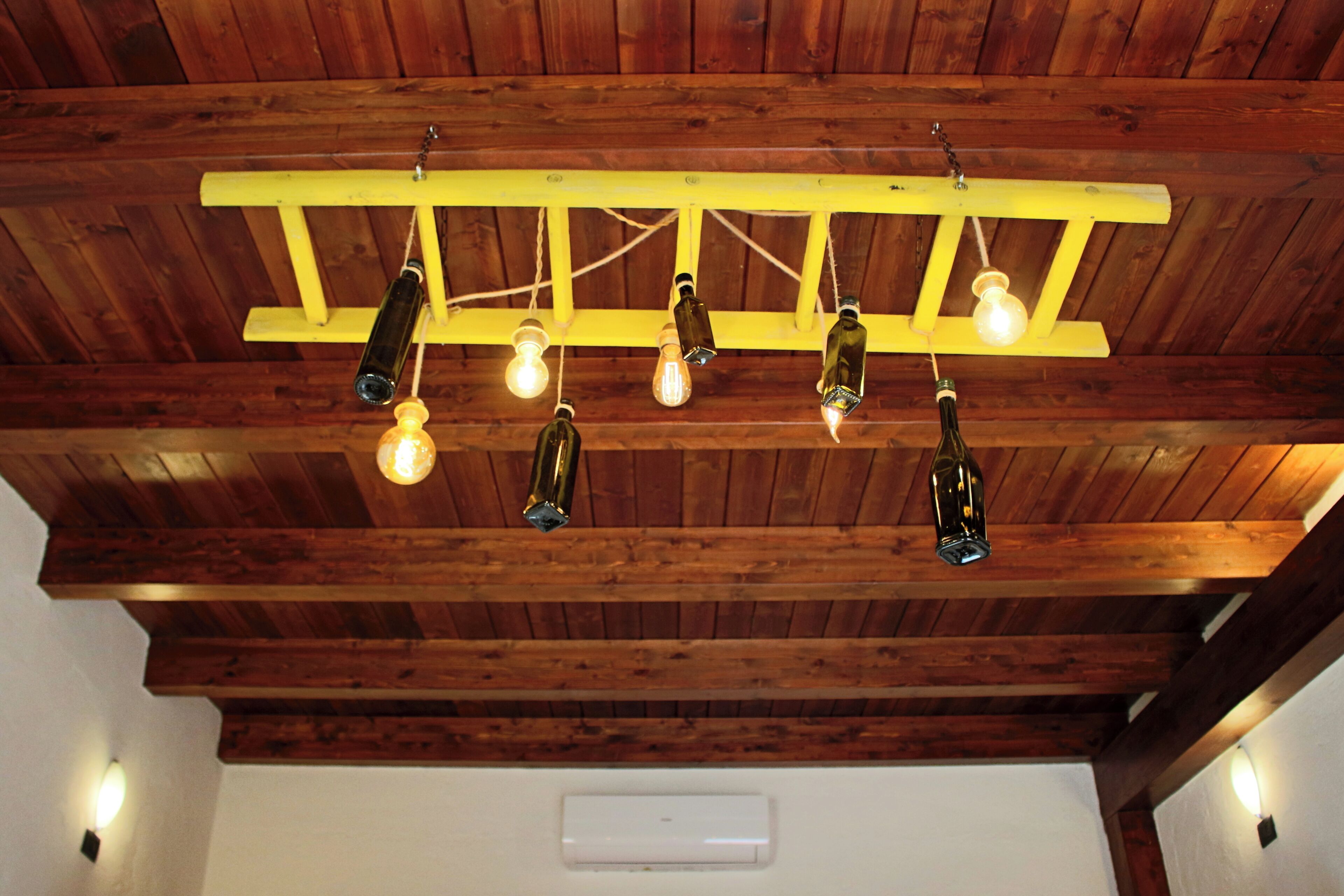 A ceiling with wooden beams and hanging light fixtures.
